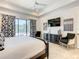 Luxurious bedroom with king bed, stylish decor, and a large TV at 550 Muirfield Loop, Reunion, FL 34747