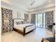 King-size bed, ensuite bathroom, walk-in closet and access to balcony at 550 Muirfield Loop, Reunion, FL 34747