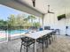 Covered patio with dining table, pool view, and ceiling fans at 550 Muirfield Loop, Reunion, FL 34747