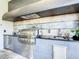 Luxury outdoor kitchen with stainless steel appliances and stone countertops at 550 Muirfield Loop, Reunion, FL 34747