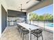 Modern outdoor kitchen with stainless steel appliances and seating area at 550 Muirfield Loop, Reunion, FL 34747