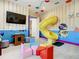 Playroom with a slide, arcade games, and colorful decor at 550 Muirfield Loop, Reunion, FL 34747