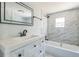 Updated bathroom with a white vanity, marble tile, and bathtub at 18925 3Rd Ave, Orlando, FL 32820