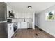 Modern kitchen featuring white cabinets, stainless steel appliances, and wood-look flooring at 18925 3Rd Ave, Orlando, FL 32820