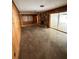 Living room with wood paneled walls and concrete floors at 4422 Meadowood St, Orlando, FL 32812
