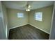 Cozy bedroom with wood-look flooring, ceiling fan, and large windows at 7204 Peyton Pl, Orlando, FL 32818