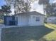 Back exterior view of a single-story home with a storage shed and grassy yard at 7204 Peyton Pl, Orlando, FL 32818