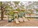 playground with slides, climbing wall, and surrounding trees at 7664 Comrow St # 305, Kissimmee, FL 34747