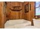 Relaxing bathroom with corner tub, wood walls, and a window at 24120 Mink Rd, Astor, FL 32102