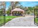 Gated entry to the property with a vintage carriage and canopy at 24120 Mink Rd, Astor, FL 32102