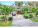 Home exterior featuring gated entrance, landscaping, and palm trees at 24120 Mink Rd, Astor, FL 32102
