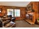Cozy living room features a wood-burning fireplace and leather armchairs at 24120 Mink Rd, Astor, FL 32102