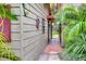 Brick pathway leads to a private backyard with lush tropical landscaping at 24120 Mink Rd, Astor, FL 32102
