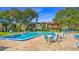 Community pool with lounge chairs and patio tables at 3800 Saxon Dr # C-52, New Smyrna Beach, FL 32169