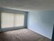Bright living room featuring light blue walls and neutral carpeting at 333 Lake Howard Nw Dr # 202C, Winter Haven, FL 33880