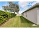 Side yard with a green lawn, hedges, and a large tree at 2178 Sunstone Dr, Lakeland, FL 33813