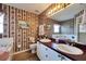 Bathroom with double vanity, a large garden tub, and decorative wallpaper at 2178 Sunstone Dr, Lakeland, FL 33813