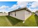 Tan house exterior with green lawn and partial view of the backyard at 2178 Sunstone Dr, Lakeland, FL 33813