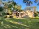 Backyard view of a home with a screened patio and lush lawn at 3022 21St Nw St, Winter Haven, FL 33881