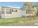 Tan single-wide mobile home with screened porch and yard at 408 Garrett Ridge Ct, Winter Haven, FL 33880
