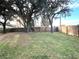 Large backyard with mature trees and wooden fence at 4201 Shadow Wood Dr, Winter Haven, FL 33880