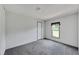 Simple bedroom with gray carpet, white walls, and a window at 10109 Old Spanish Trl, Polk City, FL 33868