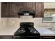 Black stove and dark wood cabinets in a modern kitchen at 10109 Old Spanish Trl, Polk City, FL 33868