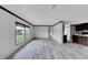 Open living area with grey plank flooring and large windows at 10109 Old Spanish Trl, Polk City, FL 33868