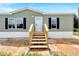 House exterior with light green siding and wooden steps at 10109 Old Spanish Trl, Polk City, FL 33868