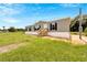 House exterior with green siding, wooden steps and grassy area at 10109 Old Spanish Trl, Polk City, FL 33868