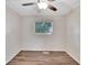 Simple bedroom with wood-look floors, window, and ceiling fan at 905 14Th Ne St, Winter Haven, FL 33881
