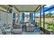 Cozy screened patio furnished with wicker seating and potted plants at 411 Sunfish Dr, Winter Haven, FL 33881