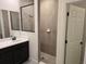 Bathroom with single vanity, dark brown cabinets and shower at 2561 Mariah Pl, Lake Alfred, FL 33850