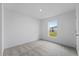 Bright bedroom with grey carpet and a window overlooking the backyard at 2211 Majestic Span Ave, Eagle Lake, FL 33839