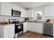 Modern kitchen with white cabinets, stainless steel appliances, and granite countertops at 2211 Majestic Span Ave, Eagle Lake, FL 33839