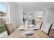 Dining area with a light wood table and beige chairs, looking into the kitchen at 2211 Majestic Span Ave, Eagle Lake, FL 33839