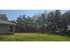 Home with grassy backyard and mature trees bordering the property at 410 St Johns Ln, Poinciana, FL 34759