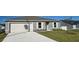 Gray house with white garage door and landscaping at 1412 Swan Ct, Poinciana, FL 34759