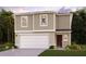 Two-story house with a large garage and landscaping at 1695 Nebraska Loop, Sumterville, FL 33585