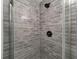 Updated shower with gray brick tile and glass enclosure at 2203 Nottingham Rd, South Daytona, FL 32119
