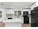 Modern kitchen with white cabinets, quartz countertops and black appliances at 2743 Fletcher Ave, Eaton Park, FL 33840