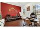 Home office with red accent wall, leather couch, and a work desk at 5240 Oakbourne Ave, Davenport, FL 33837