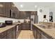 Kitchen with dark cabinets, granite countertops, and stainless steel appliances at 5240 Oakbourne Ave, Davenport, FL 33837