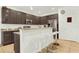 Kitchen with dark cabinetry, granite countertops, and island with seating at 5240 Oakbourne Ave, Davenport, FL 33837
