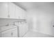 Bright laundry room with white cabinets, washer, dryer, and utility sink at 791 Terrapin Dr, Debary, FL 32713