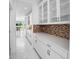 White kitchen butler's pantry with glass-front cabinets and mosaic backsplash at 791 Terrapin Dr, Debary, FL 32713