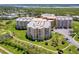 Aerial view of a large condominium complex with ocean views, pool, and tennis courts at 4670 Links Village Dr # D506, Ponce Inlet, FL 32127