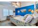 Bedroom with a blue accent wall, queen bed, and ceiling fan at 4670 Links Village Dr # D506, Ponce Inlet, FL 32127