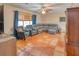 Living room with sectional sofa, terracotta tile floors, and ceiling fan at 6269 Se 125Th Pl, Belleview, FL 34420