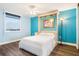 Bedroom with a queen-size bed, wall-mounted TV, and blue decor at 3370 Ocean Shore Blvd # 203B, Ormond Beach, FL 32176